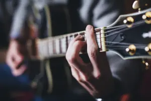Focusing a hand playing the guitar. Hands playing the guitar.