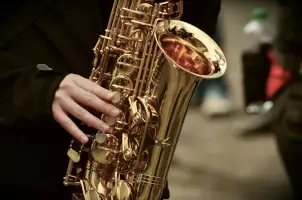Someones hand playing the saxophone.